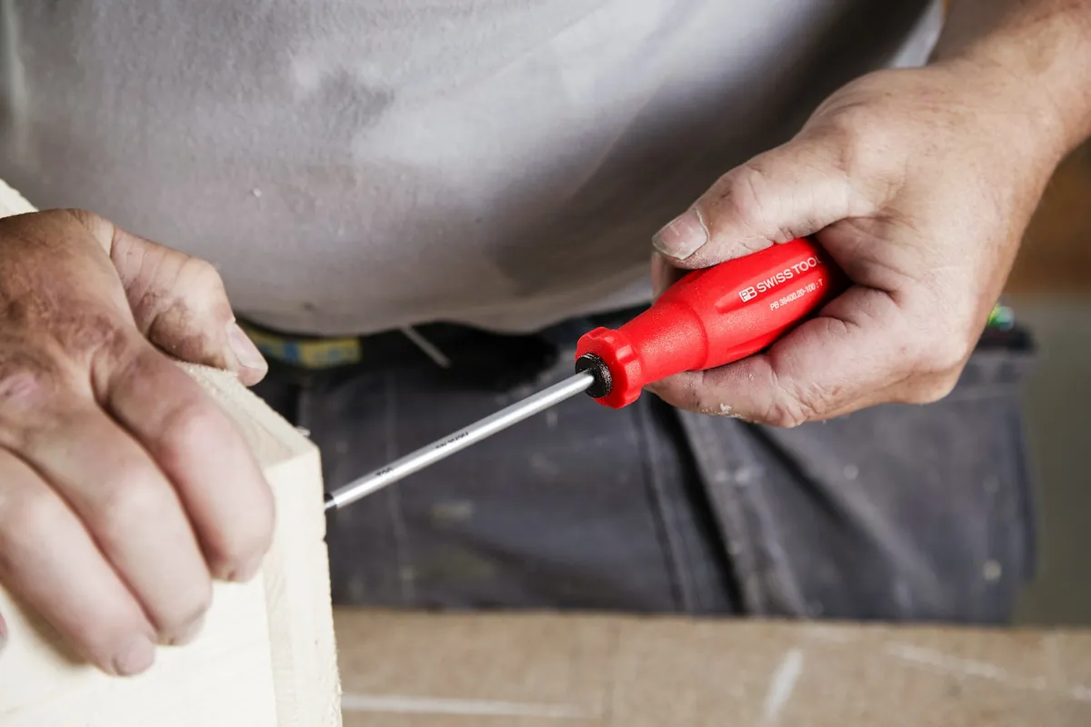 A tradesperson using a screwdriver